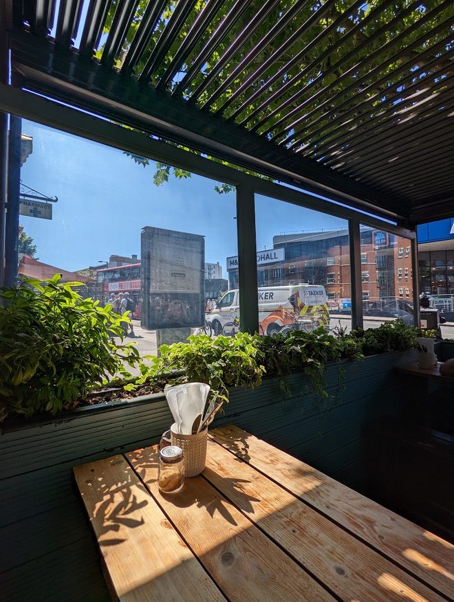 Sunlight on an empty terrace table under the pergola