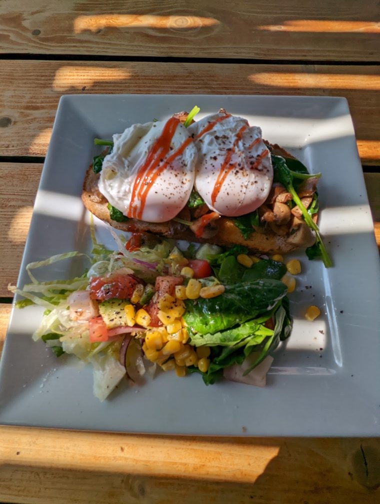 Poached eggs with bacon, sweetcorn and salad leaves